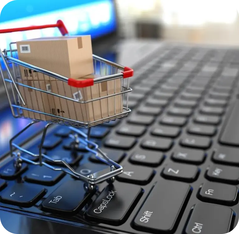 Online shopping concept with a shopping cart icon on a laptop keyboard.
